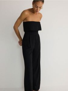 Kombinezon bez rękawów - czarny. Czarne kombinezony Reserved, l, bez wzorów, z tkaniny, bez kołnierzyka, bez ramiączek. W wyprzedaży za 89,99 zł.