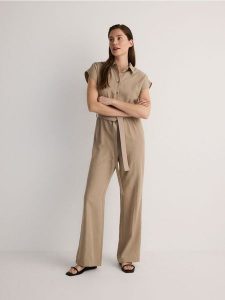 Kombinezon z lyocellu - beżowy. Brązowe kombinezony Reserved, l, bez wzorów, z lyocellu, bez kołnierzyka, bez ramiączek. W wyprzedaży za 89,99 zł.