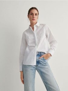 Koszula z ozdobnymi aplikacjami - biały. Białe koszule Reserved, l, z aplikacjami, z bawełny, bez kołnierzyka, bez ramiączek. W wyprzedaży za 79,99 zł.