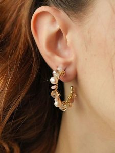 Pierres de Jade Pozłacane kolczyki-półkreole z perłami rozmiar: onesize. Brązowe kolczyki Pierres de Jade, z kryształem, pozłacane. Za 34,99 zł.