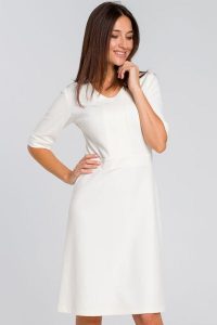 Elegancka sukienka dzianinowa trapezowa midi z dekoltem V ecru kremowa. Białe sukienki Sukienki.shop, do pracy, l, bez wzorów, z bawełny, biznesowe, bez kołnierzyka, bez ramiączek, midi, proste. Za 229,00 zł.