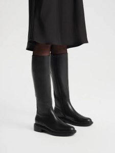 Eleganckie czarne kozaki z wąską cholewką. Czarne kozaki Ryłko, bez wzorów, z gumy, z okrągłym noskiem, bez obcasa, na obcasie, bez zapięcia. Za 699,99 zł.