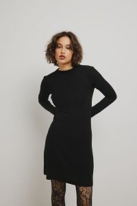 Gładka sukienka z długimi rękawami w kolorze TOTALLY BLACK - GIRONA. Czarne sukienki Marsala, bez wzorów, z elastanu, eleganckie, bez kołnierzyka, bez ramiączek, mini, rozkloszowane. Za 199,90 zł.