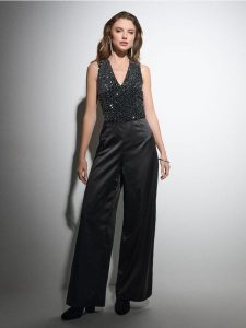 Kombinezon z cekinami - czarny. Czarne kombinezony Sinsay, l, bez wzorów, bez kołnierzyka, bez ramiączek. Za 79,99 zł.