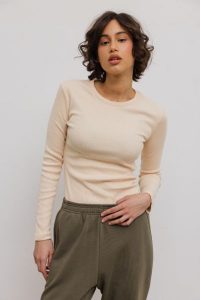 Dopasowany top z długim rękawem z prążkowanej dzianiny w kolorze BISQUIT - MOODY-S. Żółte topy Marsala, s, bez wzorów, z bawełny, bez kołnierzyka, bez ramiączek. Za 129,90 zł.