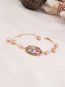 Pierres delicates Pozłacana bransoletka z perłami rozmiar: onesize. Różowe bransoletki Pierres delicates, z perłą, pozłacane. Za 65,99 zł.