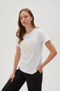 Bawełniany t-shirt z aplikacją biały. Białe t-shirty MOODO, l, z aplikacjami, z bawełny, bez kołnierzyka, bez ramiączek. W wyprzedaży za 49,99 zł.