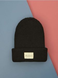 Czapka beanie - czarny. Czarne czapki Sinsay, z aplikacjami, z materiału. Za 25,99 zł.