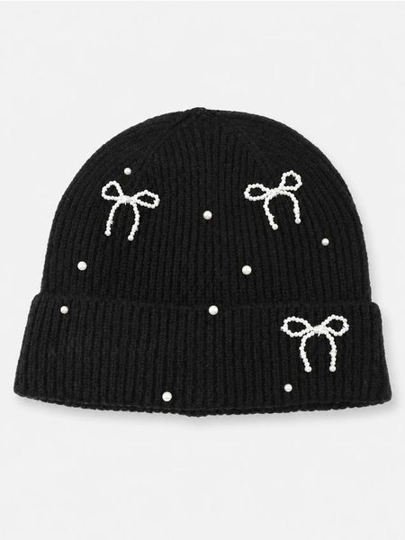 Prążkowana czapka beanie z ozdobną aplikacją kokard - czarny. Czarne czapki Sinsay, z aplikacjami, prążkowane. Za 19,99 zł.