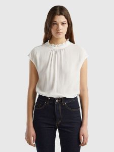 Benetton Bluzka w kolorze białym rozmiar: L. Białe bluzki Benetton, l, bez wzorów, z wiskozy, bez kołnierzyka, bez ramiączek. Za 100,99 zł.