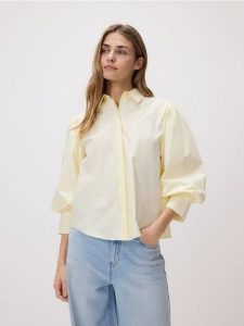 Koszula z bufiastymi rękawami - jasnożółty. Żółte koszule Reserved, l, bez wzorów, z bawełny, bez kołnierzyka, bez ramiączek. Za 139,99 zł.