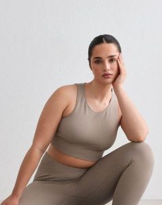 Damski crop top bezszwowy prążkowany średnie wsparcie, wyjmowane wkładki beżowy. Brązowe topy AIM'N, s, bez wzorów, z dzianiny, bez kołnierzyka, bez ramiączek. Za 197,00 zł.