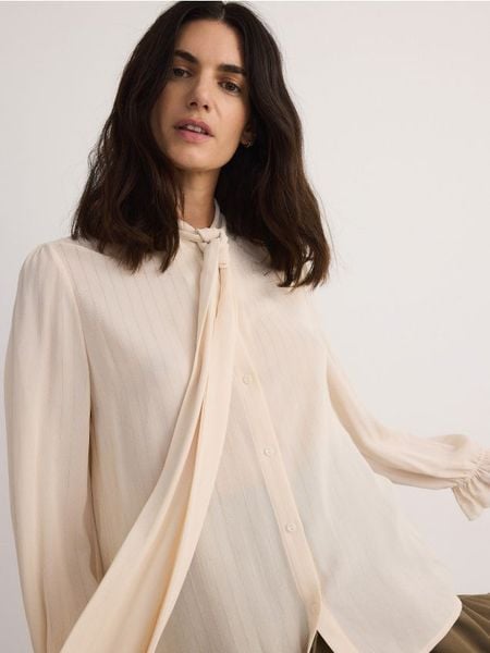 Koszula z wiązaniem przy dekolcie - złamana biel. Koszule Reserved, l, bez wzorów, z bawełny, bez kołnierzyka, bez ramiączek. W wyprzedaży za 59,99 zł.