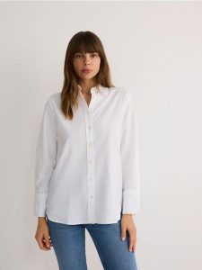 Bawełniana koszula - złamana biel. Koszule Reserved, l, bez wzorów, z bawełny, bez kołnierzyka, bez ramiączek. W wyprzedaży za 59,99 zł.