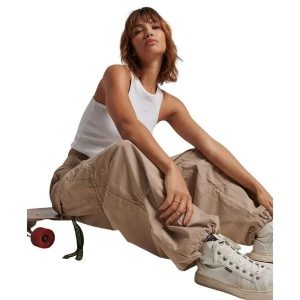 Damskie spodnie spadochronowe typu baggy Superdry. Brązowe spodnie dresowe Superdry, bez wzorów. Za 428,40 zł.