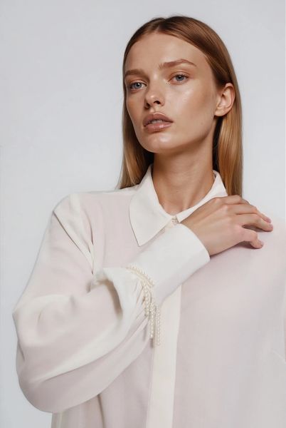 Koszula z koralikami na rękawie biała. Białe koszule MOODO, l, bez wzorów, z poliesteru, bez kołnierzyka, bez ramiączek. Za 139,99 zł.