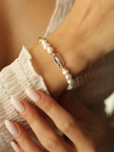 Pierres delicates Pozłacana bransoletka z kamieniami szlachetnymi i perłami rozmiar: onesize. Białe bransoletki Pierres delicates, z perłą, pozłacane. Za 52,99 zł.