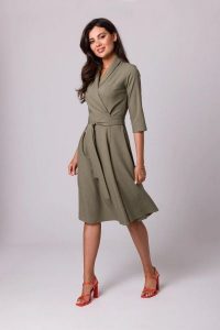 Rozkloszowana sukienka kopertowa z wiązaniem w pasie khaki. Brązowe sukienki Bewear, do pracy, m, bez wzorów, z tkaniny, biznesowe, bez kołnierzyka, bez ramiączek, dopasowane. Za 349,00 zł.