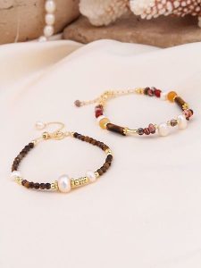 Pierres de Jade Pozłacane bransoletki (2 szt.) z perłami i kamieniami szlachetnymi rozmiar: onesize. Białe bransoletki Pierres de Jade, z perłą, pozłacane. Za 43,99 zł.