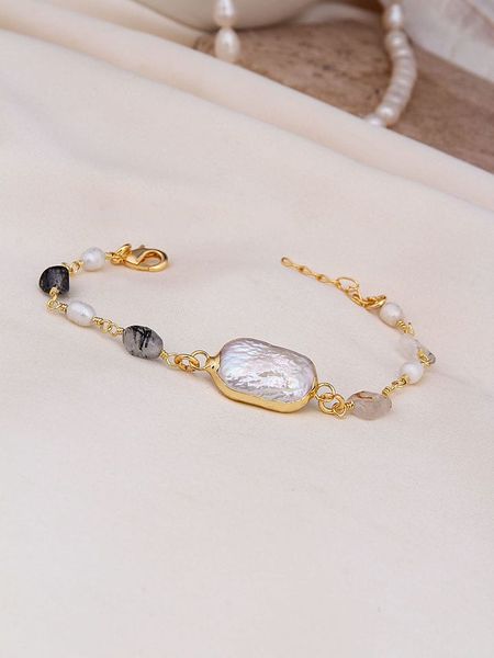 Pierres de Jade Pozłacana bransoletka z elementami ozdobnymi rozmiar: onesize. Białe bransoletki Pierres de Jade, z perłą, pozłacane. Za 43,99 zł.