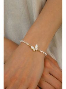 Pierres delicates Pozłacana bransoletka z elementem ozdobnym rozmiar: onesize. Białe bransoletki Pierres delicates, z perłą, pozłacane. Za 104,95 zł.