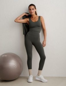 Damskie legginsy z wysokim stanem, squat proof, dla niskich Sense zielone. Zielone legginsy AIM'N, bez wzorów, z elastanu, z podwyższonym stanem, krótkie. Za 297,00 zł.