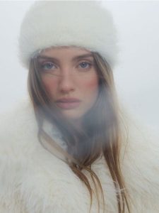 Futrzana czapka - złamana biel. Czapki Reserved, bez wzorów, z futra. W wyprzedaży za 49,99 zł.