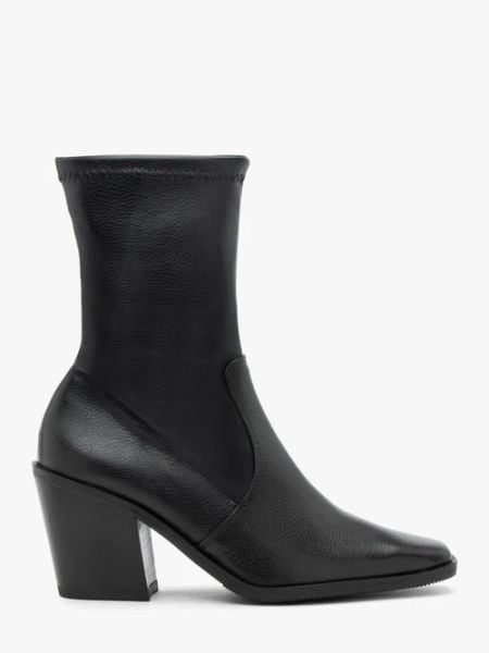 Czarne wyższe botki z elastyczną cholewką. Czarne botki Ryłko, bez wzorów, ze skóry, bez obcasa, na słupku, bez zapięcia. W wyprzedaży za 449,99 zł.