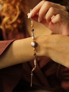 Pierres delicates Pozłacana bransoletka z kamieniami szlachetnymi i perłami rozmiar: onesize. Brązowe bransoletki Pierres delicates, z perłą, pozłacane. Za 52,99 zł.