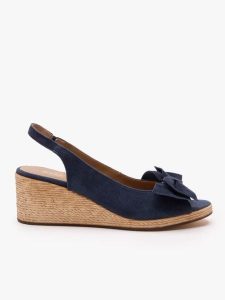 Granatowe sandały na koturnie z kokardą. Niebieskie sandały Ryłko, bez wzorów, ze skóry, z okrągłym noskiem, bez obcasa, na koturnie, bez zapięcia. Za 399,99 zł.