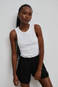 Top na ramiączkach prążkowanej dzianiny w kolorze CLASSIC WHITE - ISLA-S. Białe topy Marsala, s, bez wzorów, z bawełny, bez kołnierzyka, bez ramiączek. Za 119,90 zł.