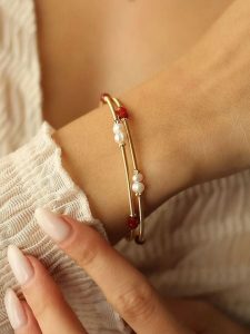 Pierres delicates Pozłacana bransoletka z kryształami i perłami rozmiar: onesize. Białe bransoletki Pierres delicates, z kryształem, pozłacane. Za 52,99 zł.