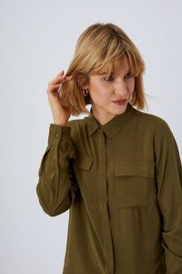 Gładka koszula z kieszeniami. Zielone koszule MOODO, xs, bez wzorów, z wiskozy, bez kołnierzyka, bez ramiączek. W wyprzedaży za 31,99 zł.