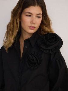 Koszula z ozdobnym kwiatem - czarny. Czarne koszule Reserved, l, bez wzorów, z bawełny, bez kołnierzyka, bez ramiączek. W wyprzedaży za 119,99 zł.