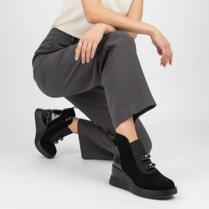 Botki damskie S. Barski, na koturnie z gumą w cholewce lakierowanej ze skóry, czarne, MR52-106. Czarne botki S.BARSKI, z aplikacjami, z gumy, bez obcasa, na koturnie, bez zapięcia. Za 254,99 zł.