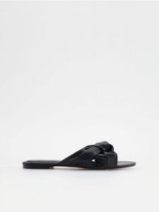 Klapki z imitacji skóry - czarny. Czarne klapki Reserved, bez wzorów, ze skóry, bez obcasa. W wyprzedaży za 39,99 zł.