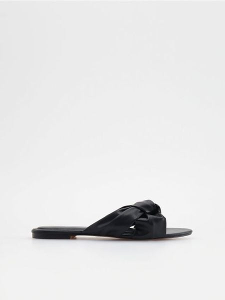 Klapki z imitacji skóry - czarny. Czarne klapki Reserved, bez wzorów, ze skóry, bez obcasa. W wyprzedaży za 39,99 zł.