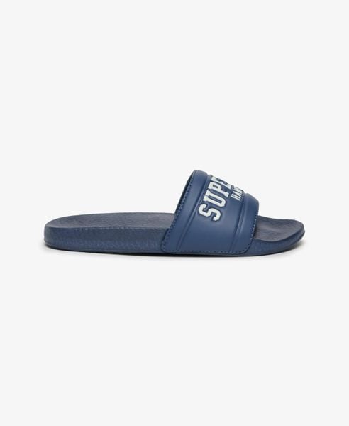 Superdry Klapki Destination Pool z poduszkowanym paskiem – Mariner Navy. Niebieskie klapki Superdry, bez wzorów, z poliesteru, bez obcasa. Za 149,30 zł.
