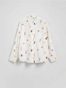 Koszula oversize z bawełnianego muślinu - złamana biel. Koszule Reserved, l, bez wzorów, z bawełny, bez kołnierzyka, bez ramiączek. W wyprzedaży za 79,99 zł.