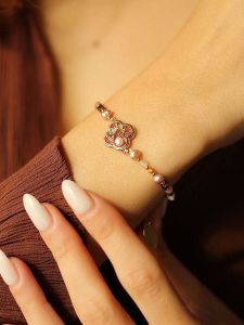 Pierres delicates Pozłacana bransoletka z kamieniami szlachetnymi i perłami rozmiar: onesize. Fioletowe bransoletki Pierres delicates, z perłą, pozłacane. Za 52,99 zł.