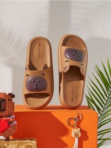 Piankowe klapki z motywem kapibary - beżowy. Brązowe klapki Sinsay, bez wzorów, bez obcasa. Za 29,99 zł.