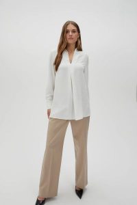 Elegancka koszula z gładkiego materiału biała. Białe koszule MOODO, l, bez wzorów, z poliesteru, bez kołnierzyka, bez ramiączek. W wyprzedaży za 49,99 zł.