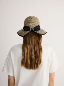 Pleciony kapelusz z kokardą - beżowy. Brązowe kapelusze Reserved, bez wzorów. W wyprzedaży za 59,99 zł.