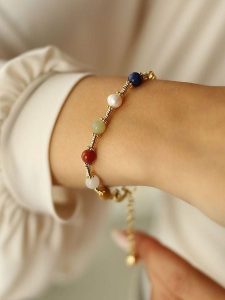 Pierres delicates Pozłacana bransoletka z kamieniami szlachetnymi i perłami rozmiar: onesize. Białe bransoletki Pierres delicates, z perłą, pozłacane. Za 52,99 zł.