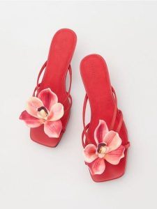 Skórzane klapki z dekoracyjnym kwiatem - czerwony. Czerwone klapki Reserved, bez wzorów, ze skóry, bez obcasa. W wyprzedaży za 79,99 zł.