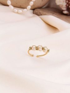 Pierres de Jade Pozłacany pierścionek z perłami i kryształami rozmiar: onesize. Białe pierścionki Pierres de Jade, z kryształem, pozłacane. Za 26,99 zł.