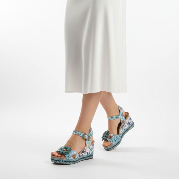 Sandały damskie Laura Vita, ze skóry naturalnej z kwiatowym nadrukiem i ozdobną aplikacją na pasku z przodu, niebieskie, 75 AC1198-75. Niebieskie sandały LAURA VITA, z aplikacjami, ze skóry, bez obcasa, na koturnie, bez zapięcia. Za 314,90 zł.