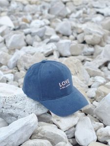 Czapka z daszkiem - granatowy. Niebieskie czapki Sinsay, bez wzorów, z bawełny. Za 19,99 zł.