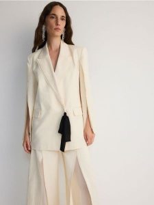 Dwurzędowa marynarka z rozcięciami - kremowy. Białe marynarki i żakiety Reserved, l, bez wzorów, z bawełny. W wyprzedaży za 279,99 zł.