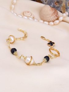 L'Atelier de Gaia Pozłacana bransoletka z onyksem i perłami rozmiar: onesize. Białe bransoletki L'Atelier de Gaia, z onyksem, pozłacane. Za 60,99 zł.